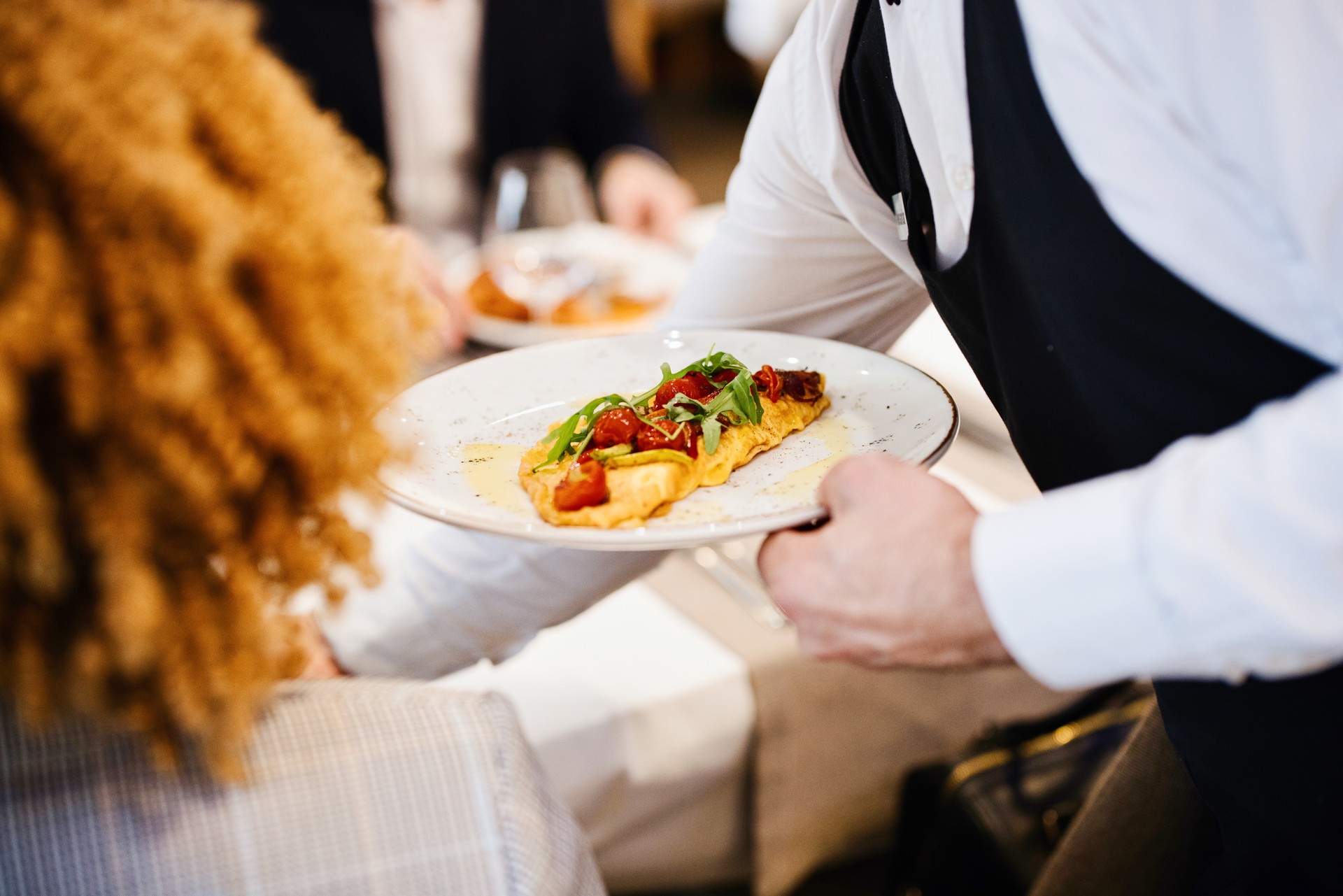 Waiter serving breakfast to the guests